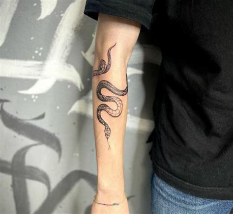 snake wrapping around forearm tattoo.